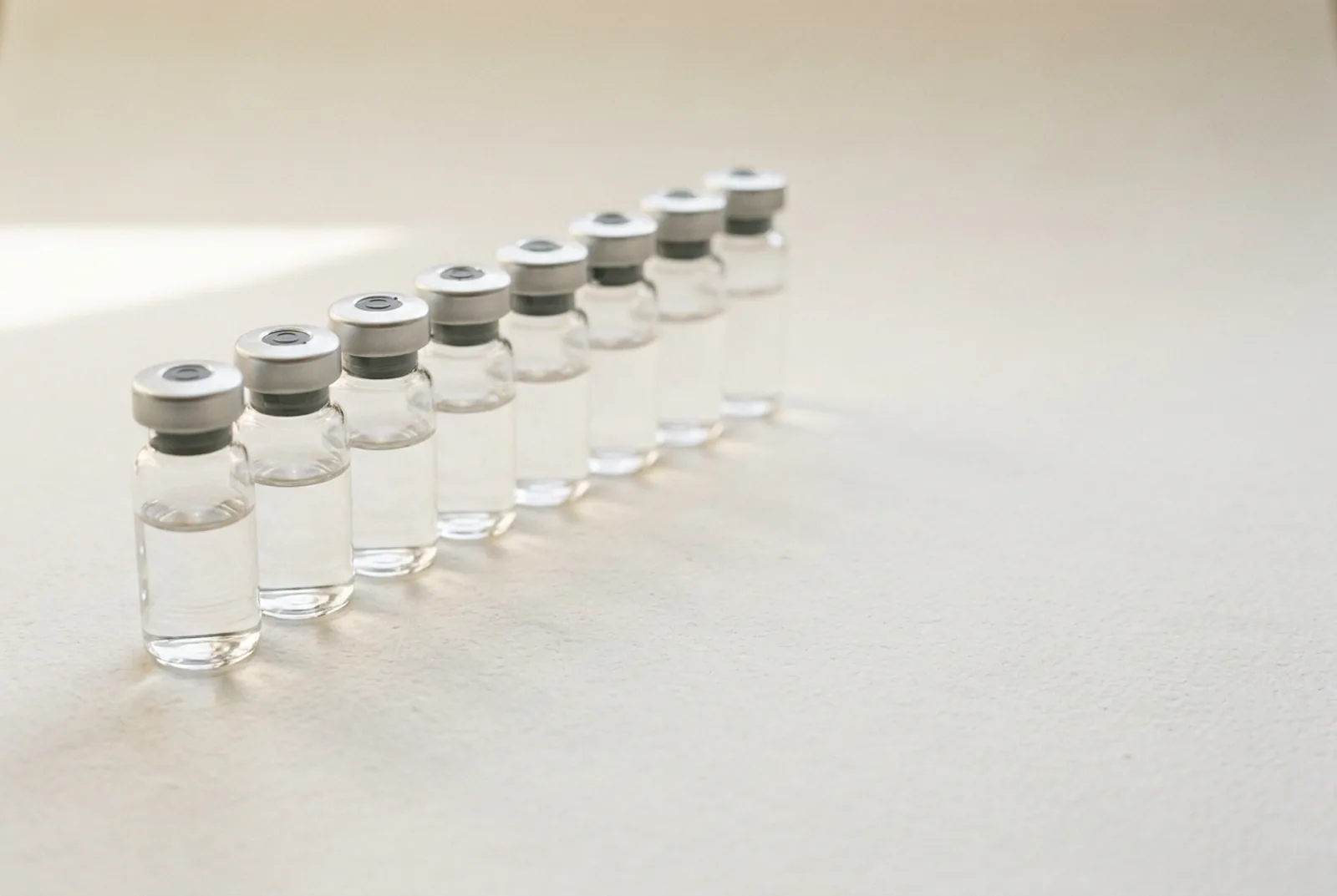 A row of clear glass vials with no printing of any kind